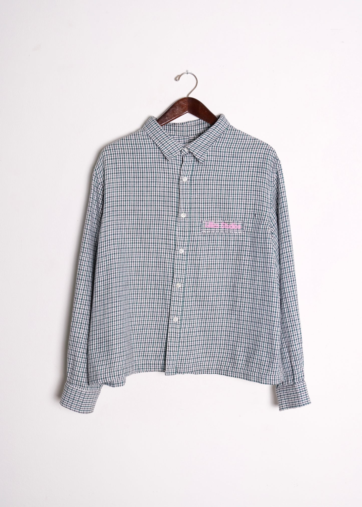 (hanger front): 1960's Blue Check Flannel Shirt – front on hanger, vintage blue micro-check long-sleeve shirt with pink Lillies Studios chest embroidery, upcycled – Lillies Studios