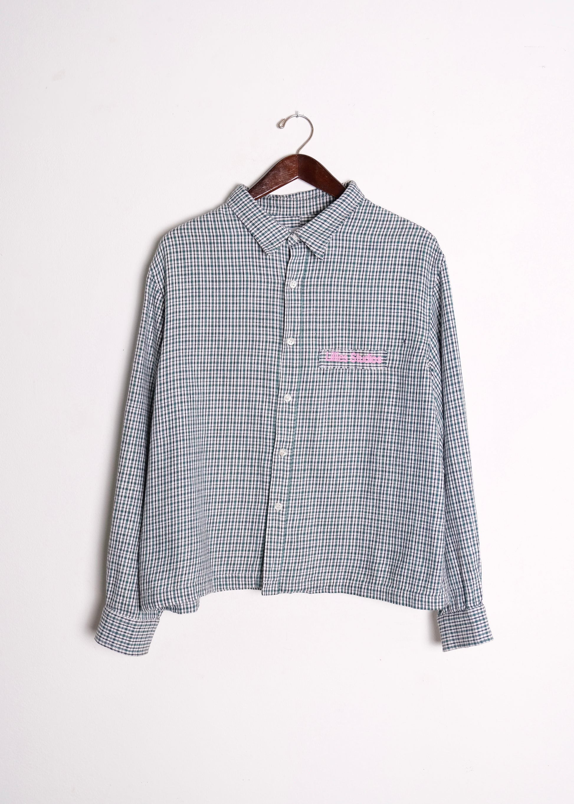 (hanger front): 1960's Blue Check Flannel Shirt – front on hanger, vintage blue micro-check long-sleeve shirt with pink Lillies Studios chest embroidery, upcycled – Lillies Studios