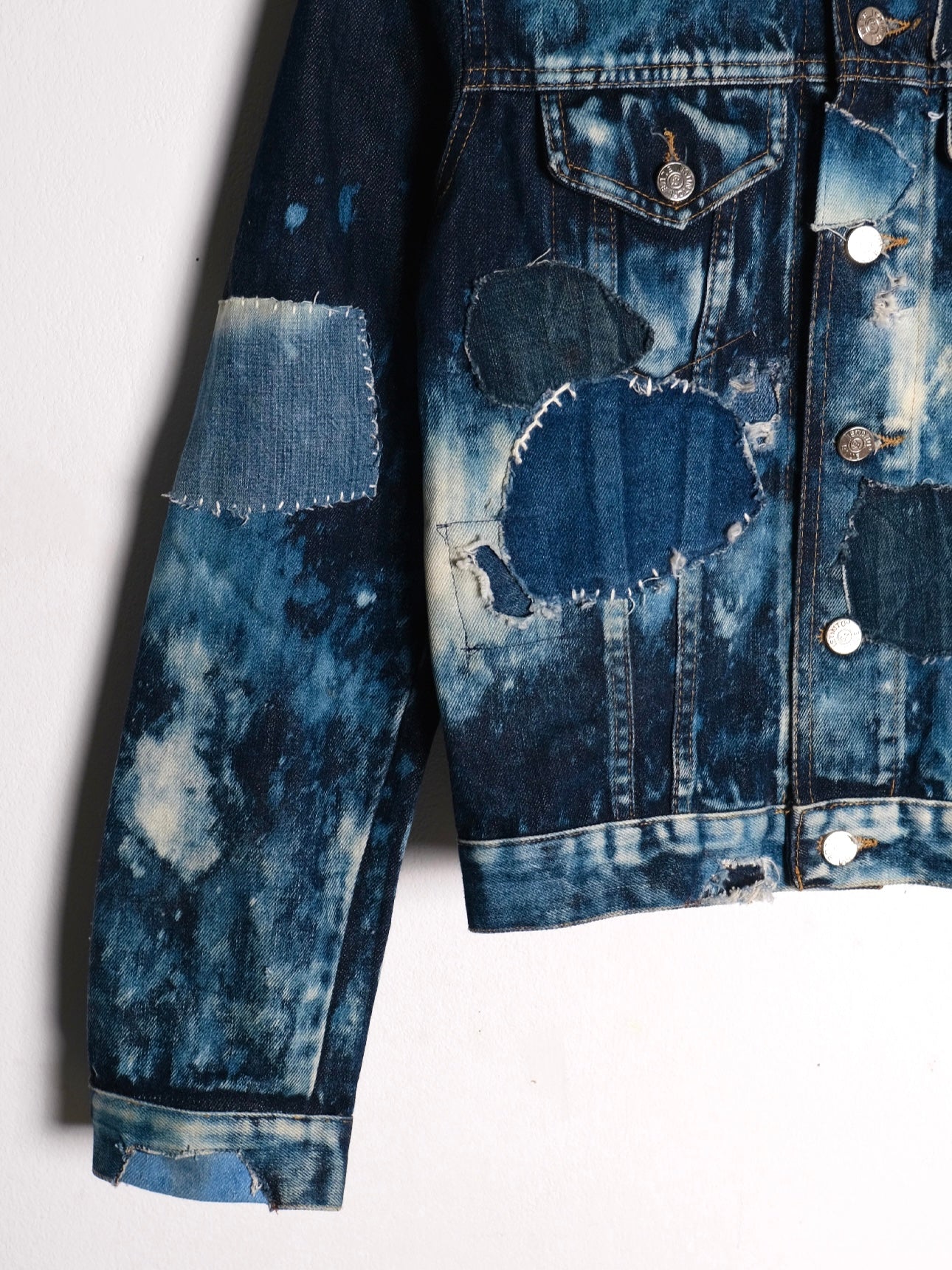 (sleeve detail): Bleached Patchwork Denim Jacket – sleeve and chest detail, dark indigo bleach tie-dye denim with raw-edge patchwork repairs and silver buttons, upcycled – Lillies Studios