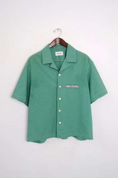 (hanger front): Cuban Collar Shirt Green – front on hanger, green micro-check camp collar shirt with Lillies Studios embroidered chest logo – Lillies Studios