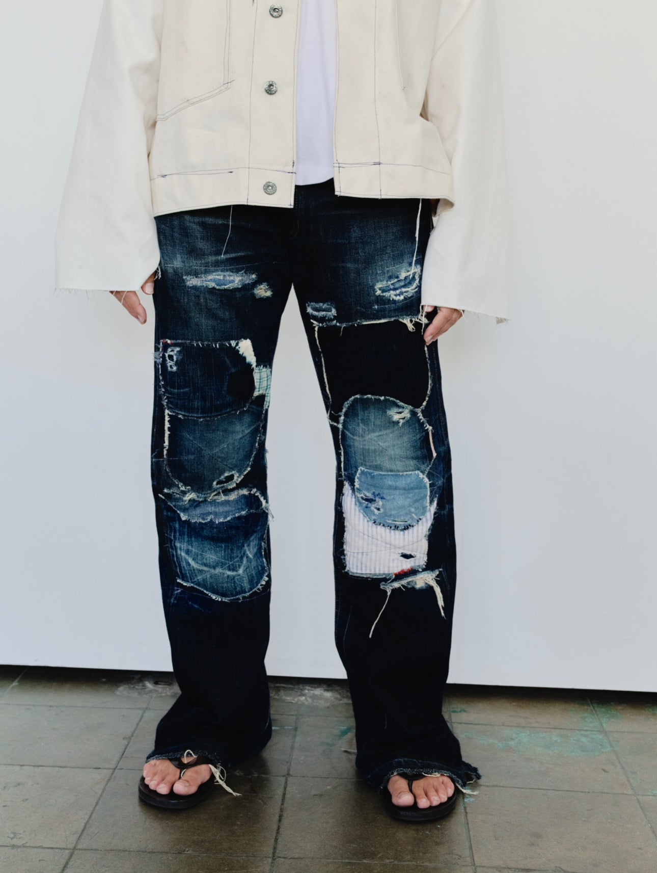 (worn detail): Japanese Selvedge Patchwork Denim – close-up worn, dark indigo patchwork knee detail with frayed mixed fabric patches – Lillies Studios