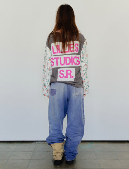 Long Sleeve Up-cycled Vintage Tee – back view worn, grey body with pink Lillies Studios S.R. graphic and floral patchwork sleeves, styled with wide-leg jeans – Lillies Studios
