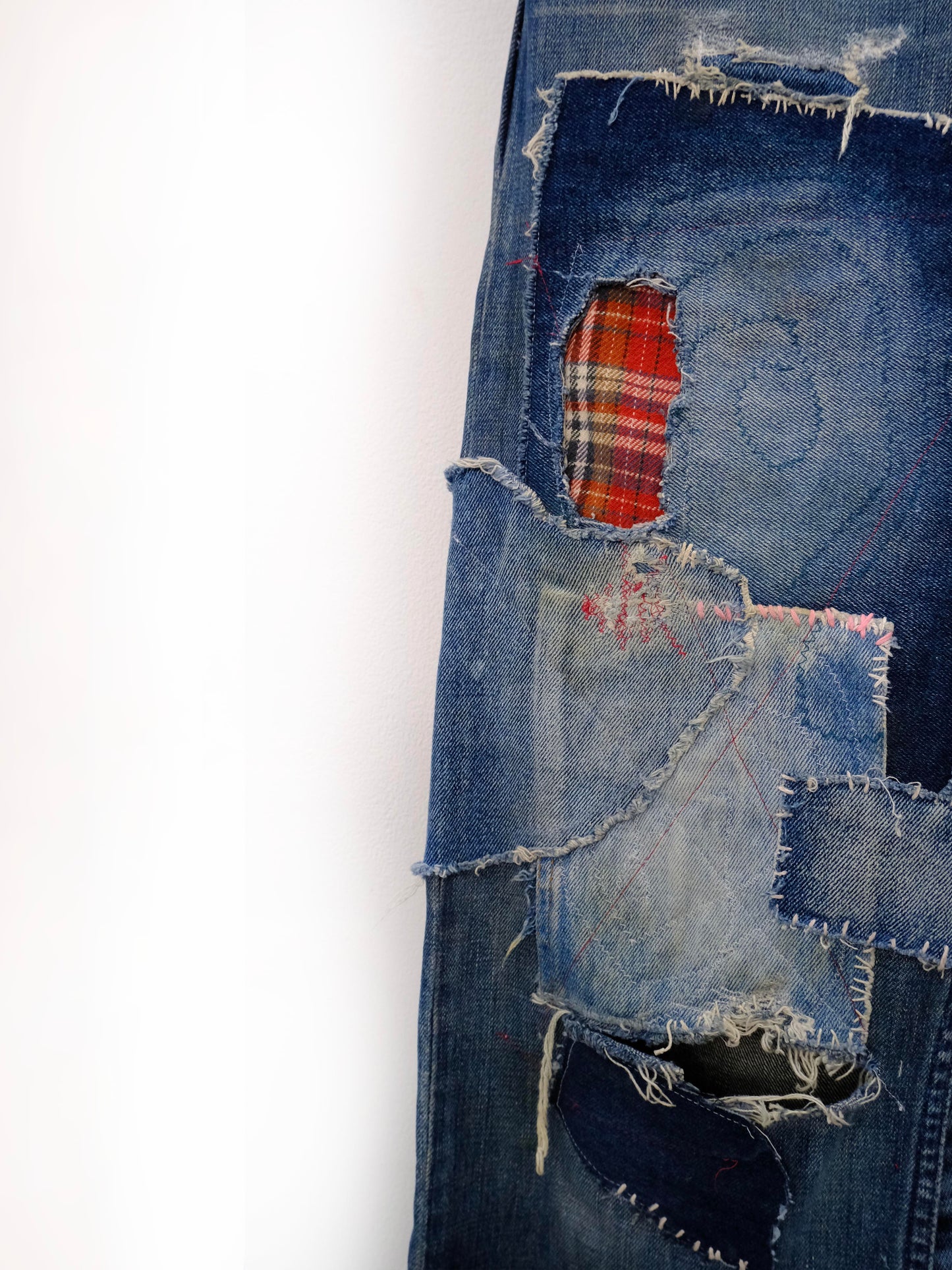 (left leg detail): Wide Leg Japanese Patchwork Denim – left leg close-up, red tartan and bleached denim patchwork with raw edge repairs, upcycled – Lillies Studios